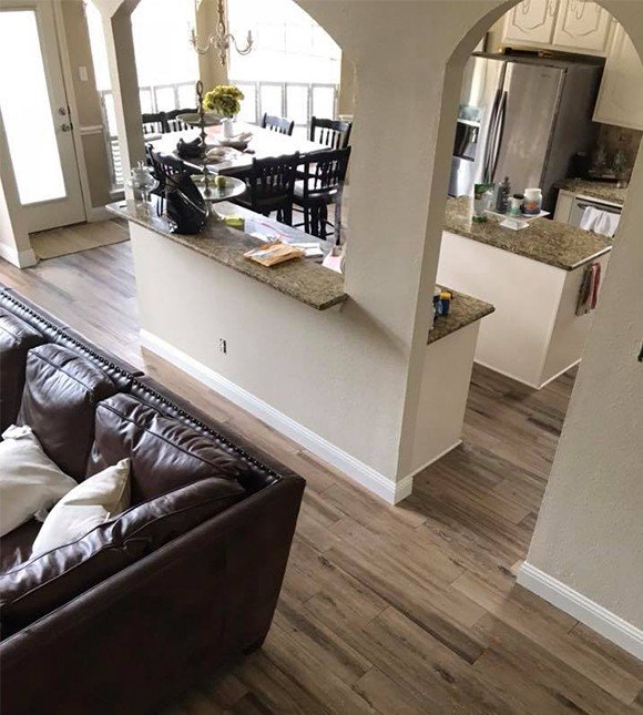Laminate flooring in open floor plan living dining kitchen space